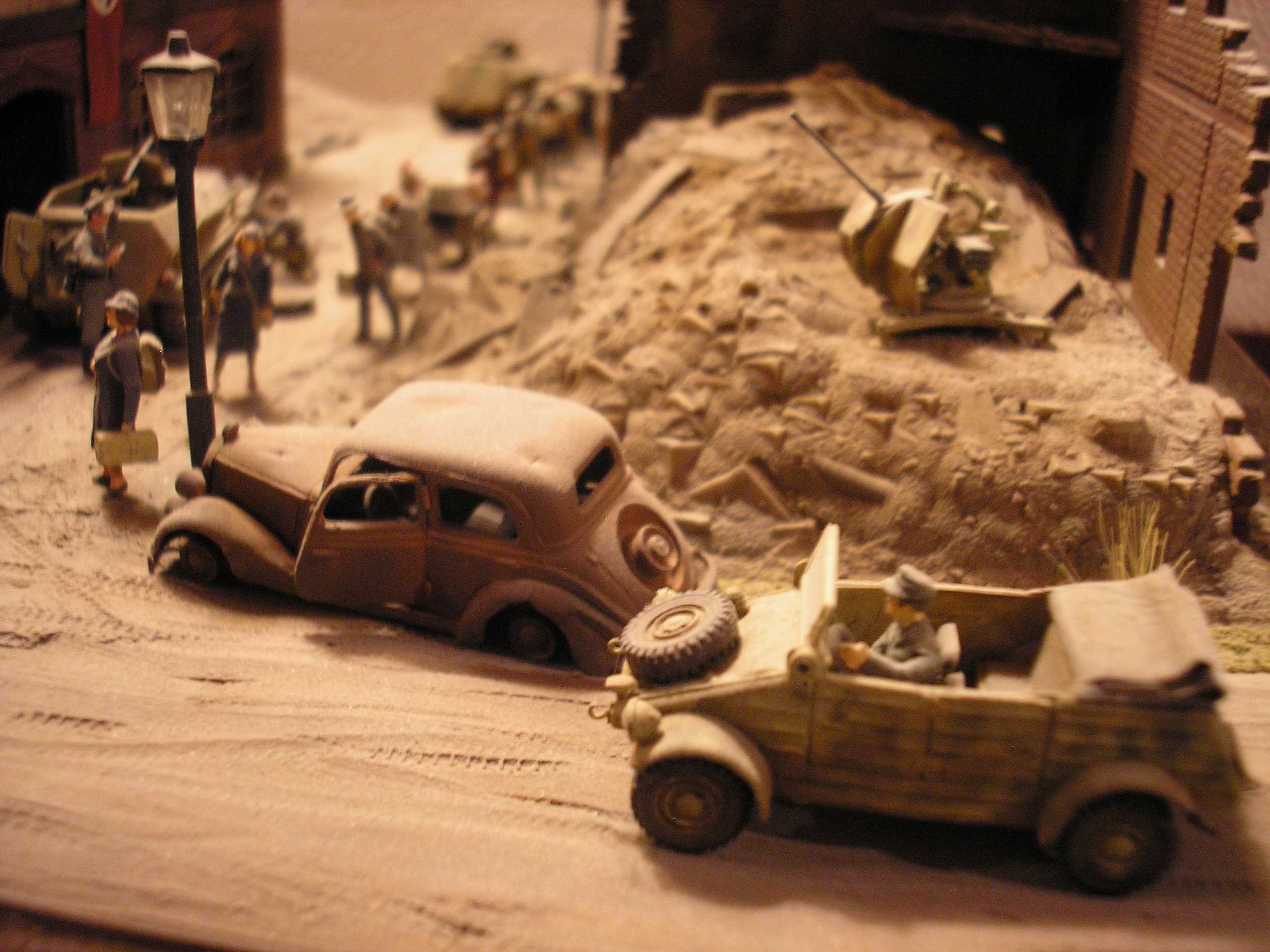 A kubelwagen passing a fire damaged Mercedes Benz 170